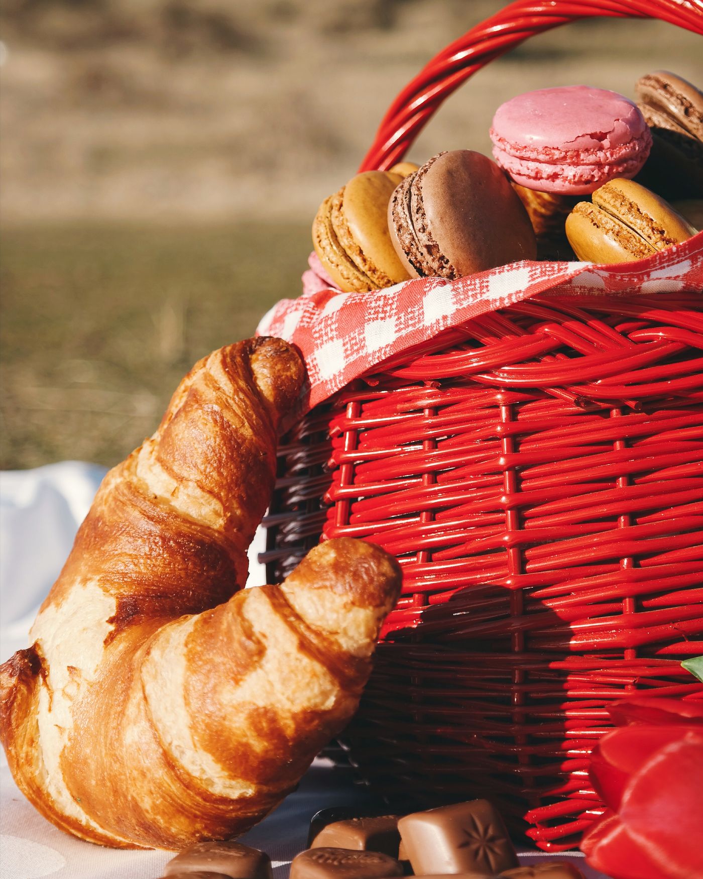 Goldbraune Croissants und Gebäck neben einem roten Frühstückskorb